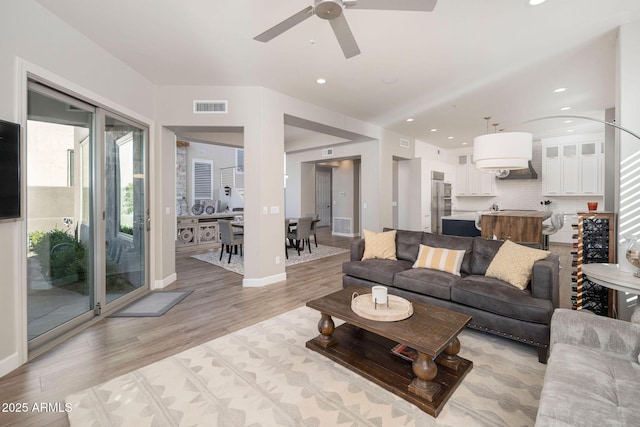 living room with light wood-type flooring and ceiling fan