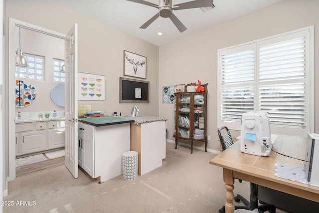 carpeted home office featuring ceiling fan