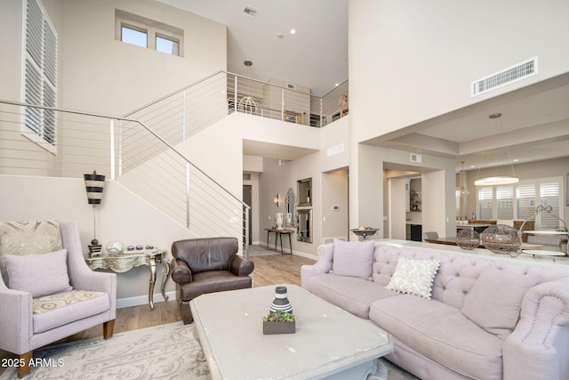 living room with a high ceiling and light hardwood / wood-style flooring