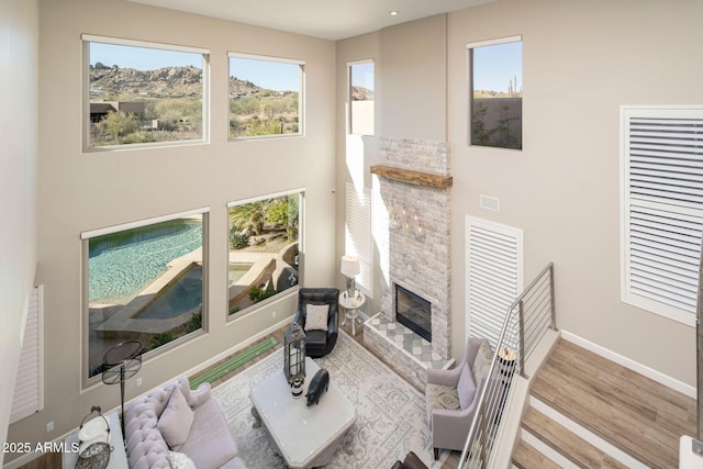 living room featuring wood-type flooring and a stone fireplace