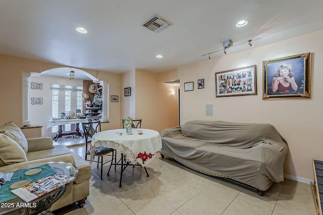 living room featuring light tile patterned floors, visible vents, arched walkways, and recessed lighting