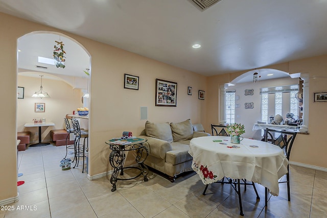 dining space with visible vents, arched walkways, light tile patterned floors, baseboards, and ornate columns