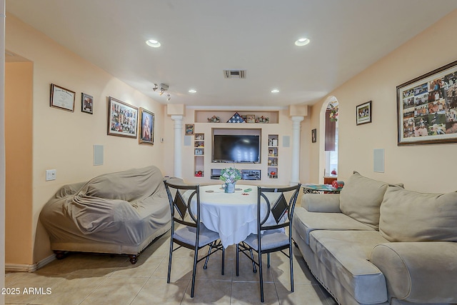 living area featuring built in shelves, light tile patterned floors, visible vents, ornate columns, and recessed lighting