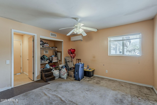 interior space with a wall mounted air conditioner, visible vents, a ceiling fan, carpet floors, and baseboards