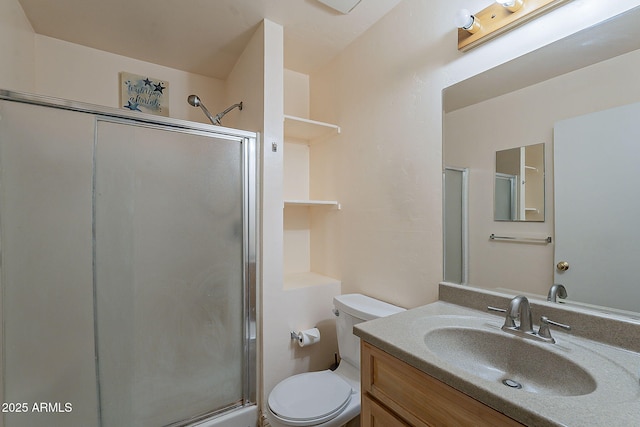 full bathroom featuring vanity, a shower stall, and toilet