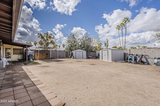 view of yard featuring an outbuilding, a fenced backyard, and a shed