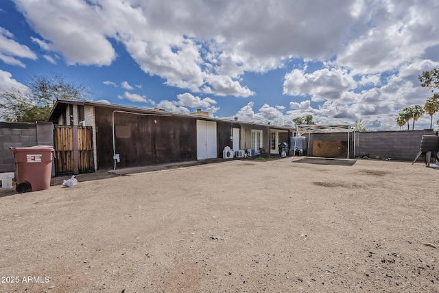 back of property with a gate and fence