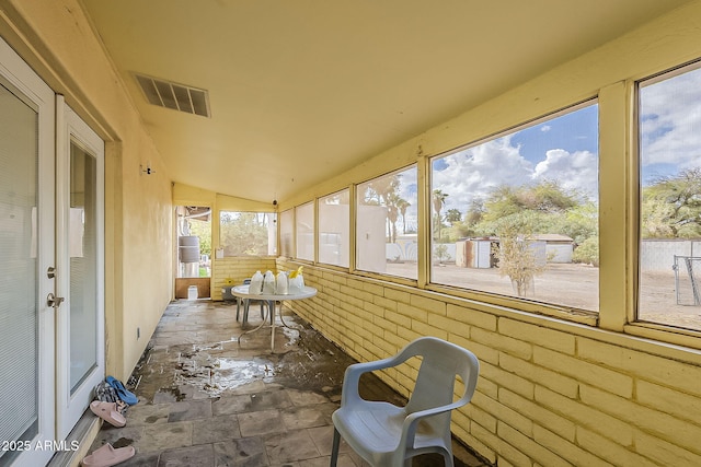 sunroom / solarium featuring lofted ceiling and visible vents