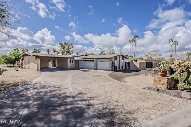 view of front of home featuring driveway, fence, a garage, and a gate