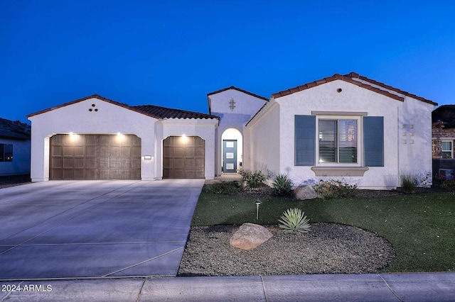 mediterranean / spanish house featuring a front yard and a garage