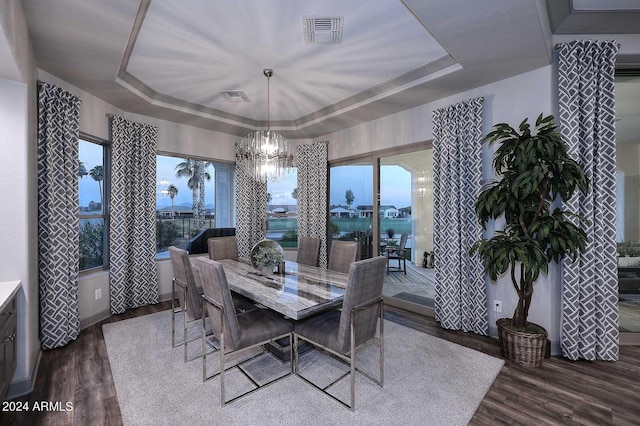 dining room featuring hardwood / wood-style flooring, a chandelier, and a tray ceiling