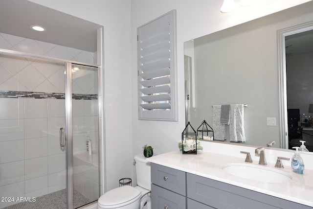 bathroom with an enclosed shower, vanity, and toilet