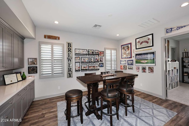 dining room with dark hardwood / wood-style flooring and a healthy amount of sunlight