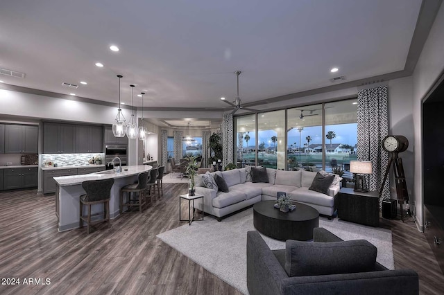 living room with sink, dark hardwood / wood-style floors, and an inviting chandelier