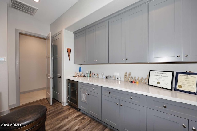 kitchen featuring dark hardwood / wood-style floors, beverage cooler, and gray cabinetry