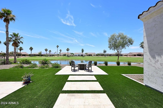 view of property's community with a lawn, a water view, and a patio