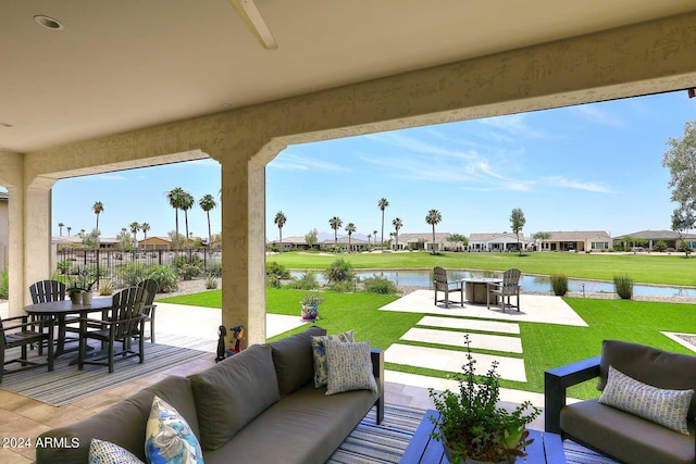 view of patio with outdoor lounge area, a water view, and ceiling fan