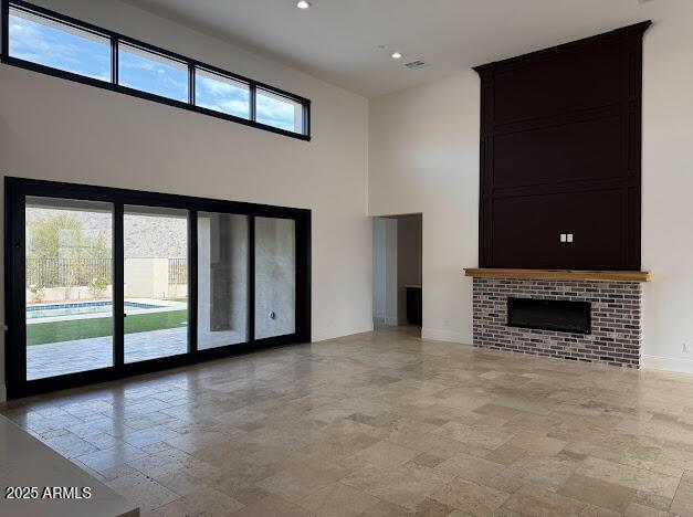 unfurnished living room featuring a high ceiling and a wealth of natural light