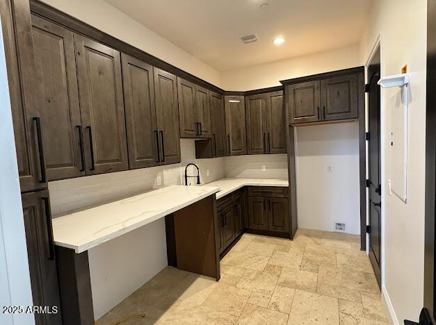 kitchen with dark brown cabinetry and sink