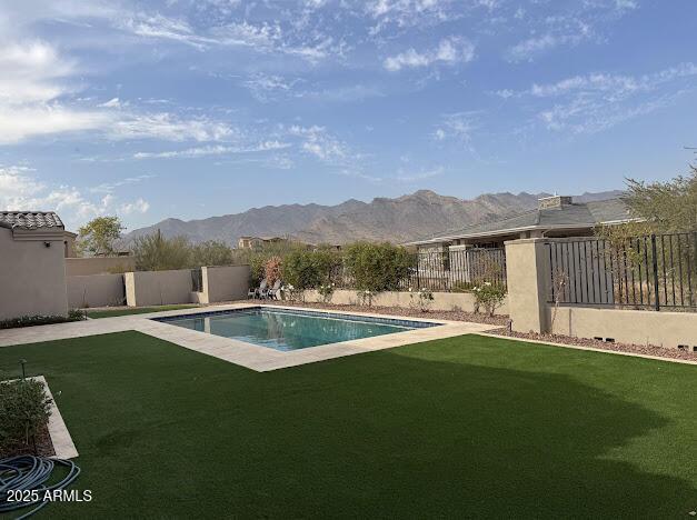 view of pool featuring a lawn and a mountain view