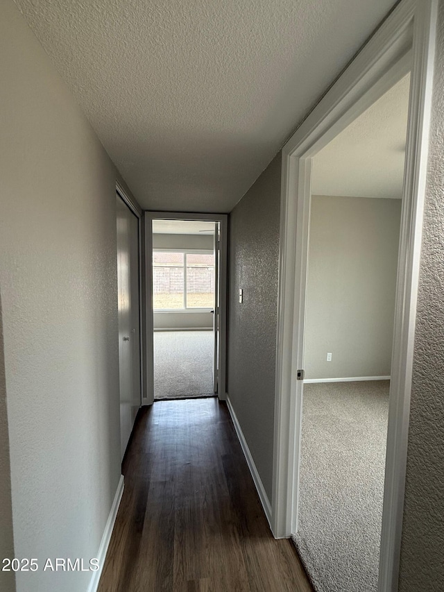 3749 W Gelding Dr, Phoenix, AZ 85053 - corridor with a textured ceiling, baseboards, dark wood-style flooring, and a textured wall