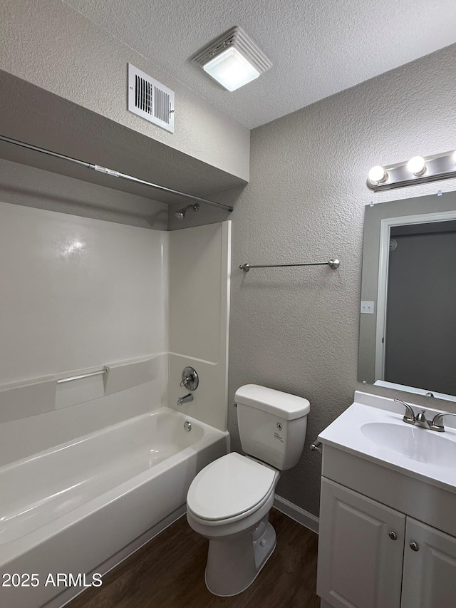 3749 W Gelding Dr, Phoenix, AZ 85053 - full bathroom featuring wood finished floors, vanity, bathtub / shower combination, toilet, and a textured wall