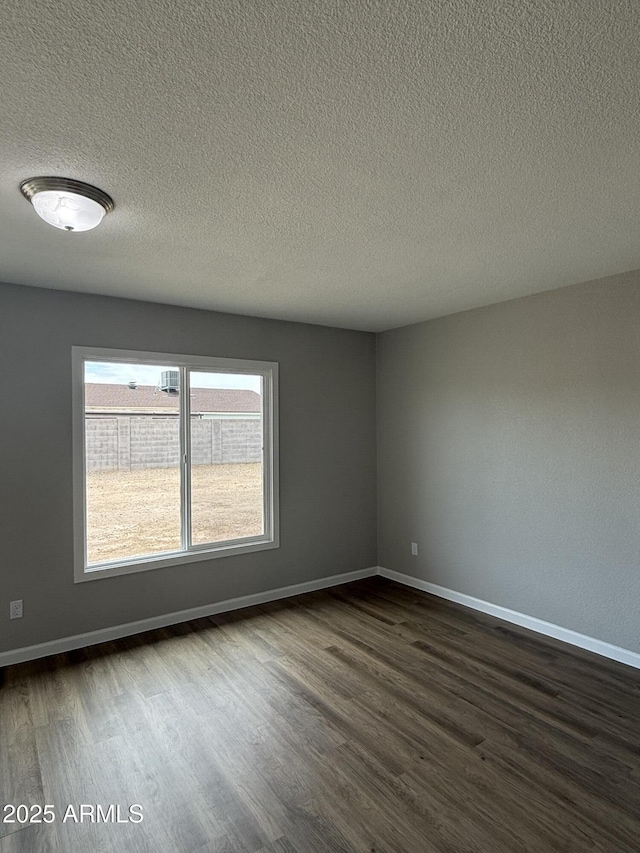 3749 W Gelding Dr, Phoenix, AZ 85053 - unfurnished room with dark wood-style floors, a textured ceiling, and baseboards