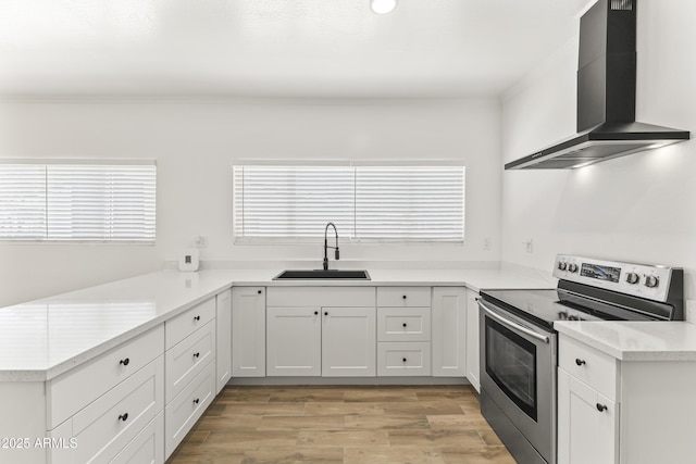 5808 W Myrtle Ave, Glendale, AZ 85301 - kitchen featuring stainless steel range with electric cooktop, wall chimney exhaust hood, a sink, light wood-style floors, and light countertops