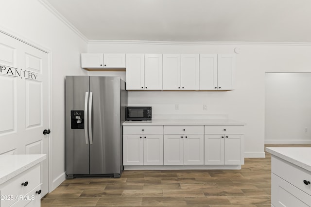 5808 W Myrtle Ave, Glendale, AZ 85301 - kitchen with stainless steel fridge, black microwave, ornamental molding, light countertops, and white cabinets
