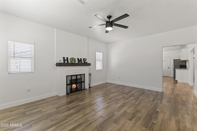 5808 W Myrtle Ave, Glendale, AZ 85301 - unfurnished living room featuring wood finished floors, ceiling fan, a brick fireplace, and baseboards