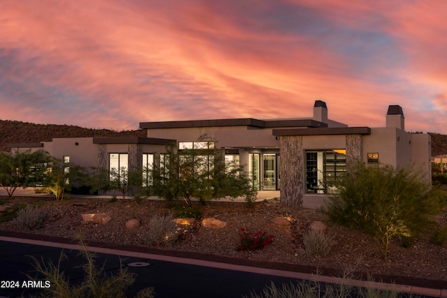 view of back house at dusk