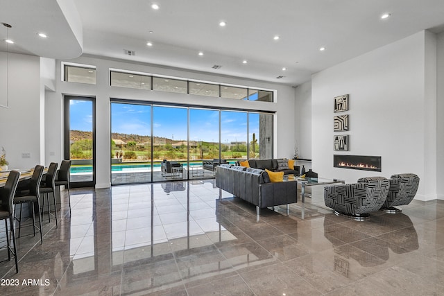 living room with a towering ceiling and a healthy amount of sunlight