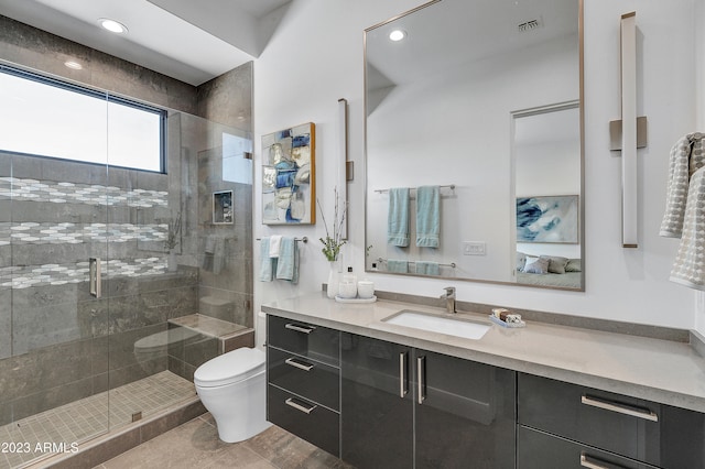 bathroom with a shower with door, vanity, toilet, and tile patterned floors