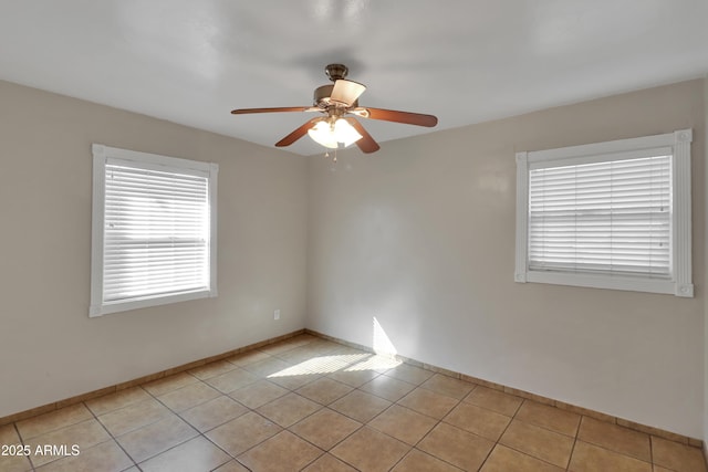 unfurnished room with ceiling fan, baseboards, and light tile patterned flooring