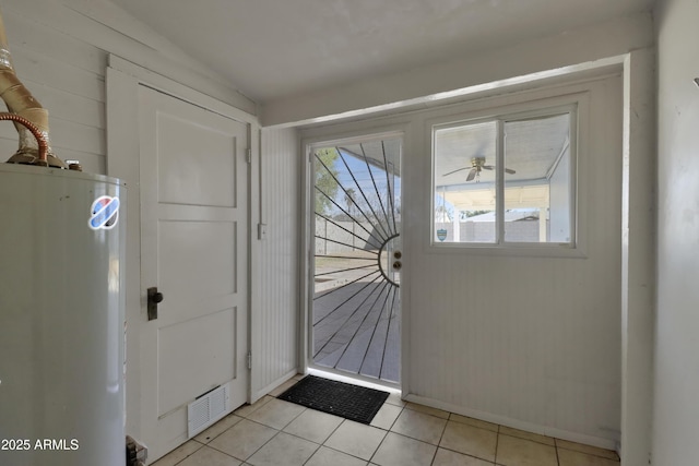 doorway to outside featuring light tile patterned floors and water heater