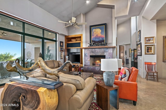 living room with a tile fireplace, high vaulted ceiling, and ceiling fan