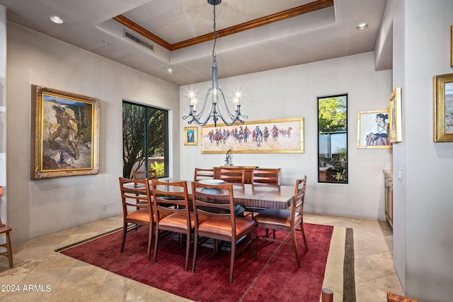 dining room featuring a raised ceiling, crown molding, and a chandelier