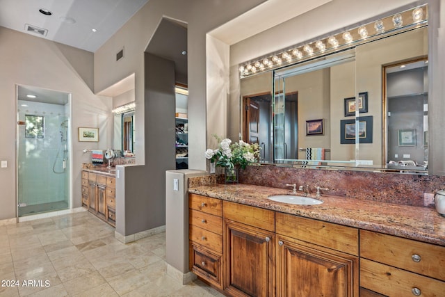 bathroom featuring tile patterned flooring, vanity, a shower, and a high ceiling