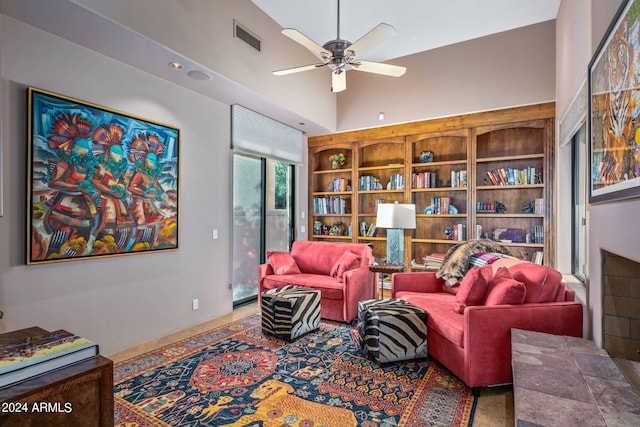 sitting room with ceiling fan and a towering ceiling