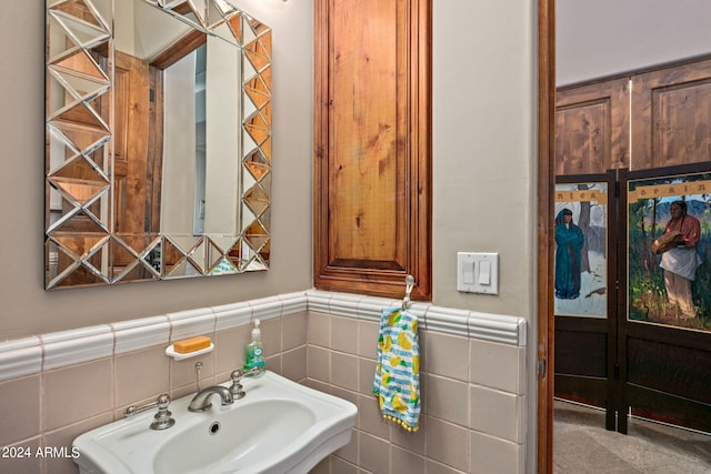 bathroom with sink and tile walls