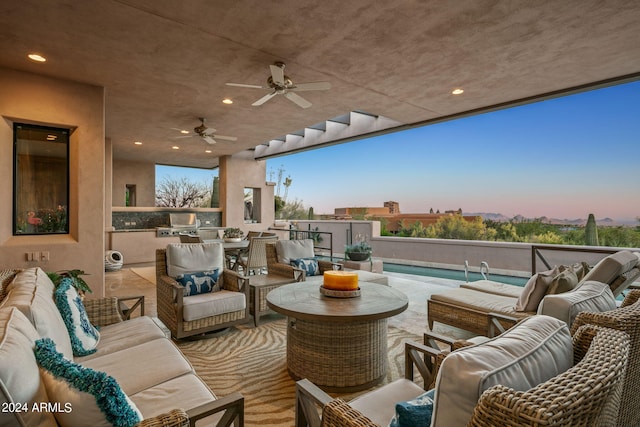 patio terrace at dusk featuring ceiling fan and a fenced in pool