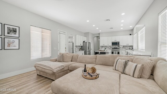 3103 S Benton, Mesa, AZ 85212 - living area with light wood-style floors, arched walkways, recessed lighting, and baseboards
