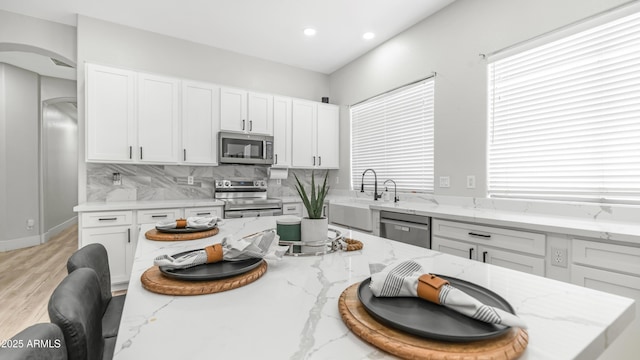3103 S Benton, Mesa, AZ 85212 - kitchen featuring stainless steel appliances, arched walkways, a kitchen bar, a sink, and white cabinetry