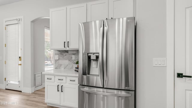 3103 S Benton, Mesa, AZ 85212 - kitchen with stainless steel fridge with ice dispenser, decorative backsplash, arched walkways, light wood-type flooring, and white cabinets