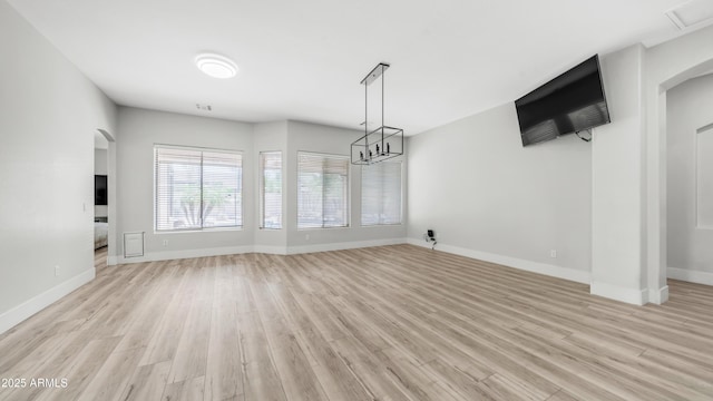 3103 S Benton, Mesa, AZ 85212 - unfurnished living room with arched walkways, light wood-style floors, and baseboards