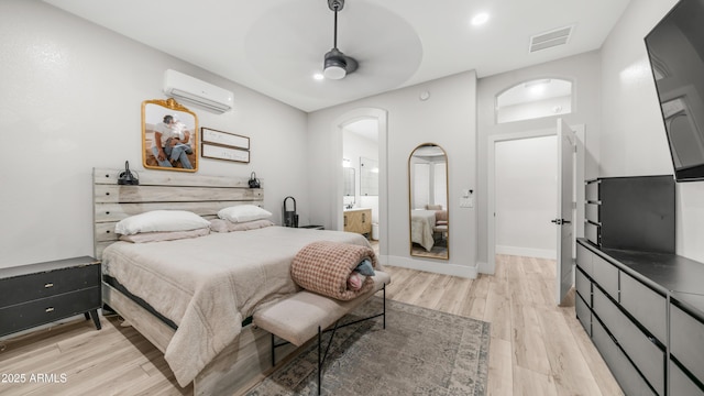 3103 S Benton, Mesa, AZ 85212 - bedroom featuring a wall unit AC, light wood-type flooring, arched walkways, ensuite bath, and a ceiling fan