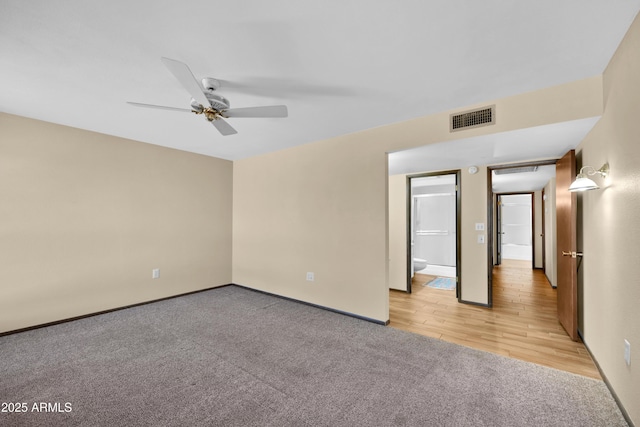 unfurnished room featuring light carpet, visible vents, and a ceiling fan