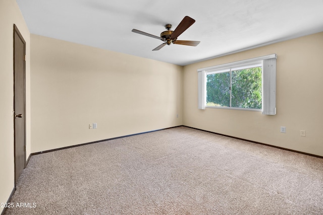 empty room with carpet floors, ceiling fan, and baseboards