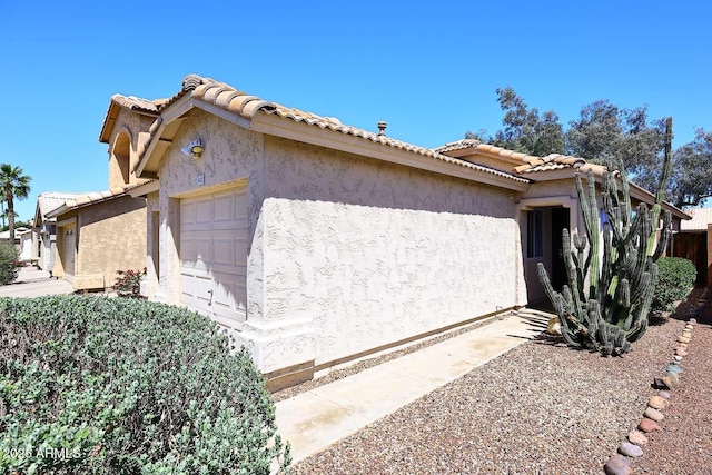3122 E Kristal Way, Phoenix, AZ 85050 - view of home's exterior featuring a garage, a tiled roof, and stucco siding