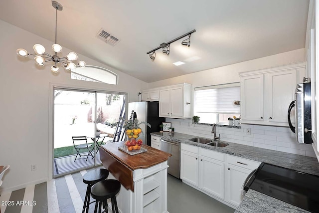 3122 E Kristal Way, Phoenix, AZ 85050 - kitchen featuring appliances with stainless steel finishes, a sink, backsplash, white cabinetry, and a chandelier